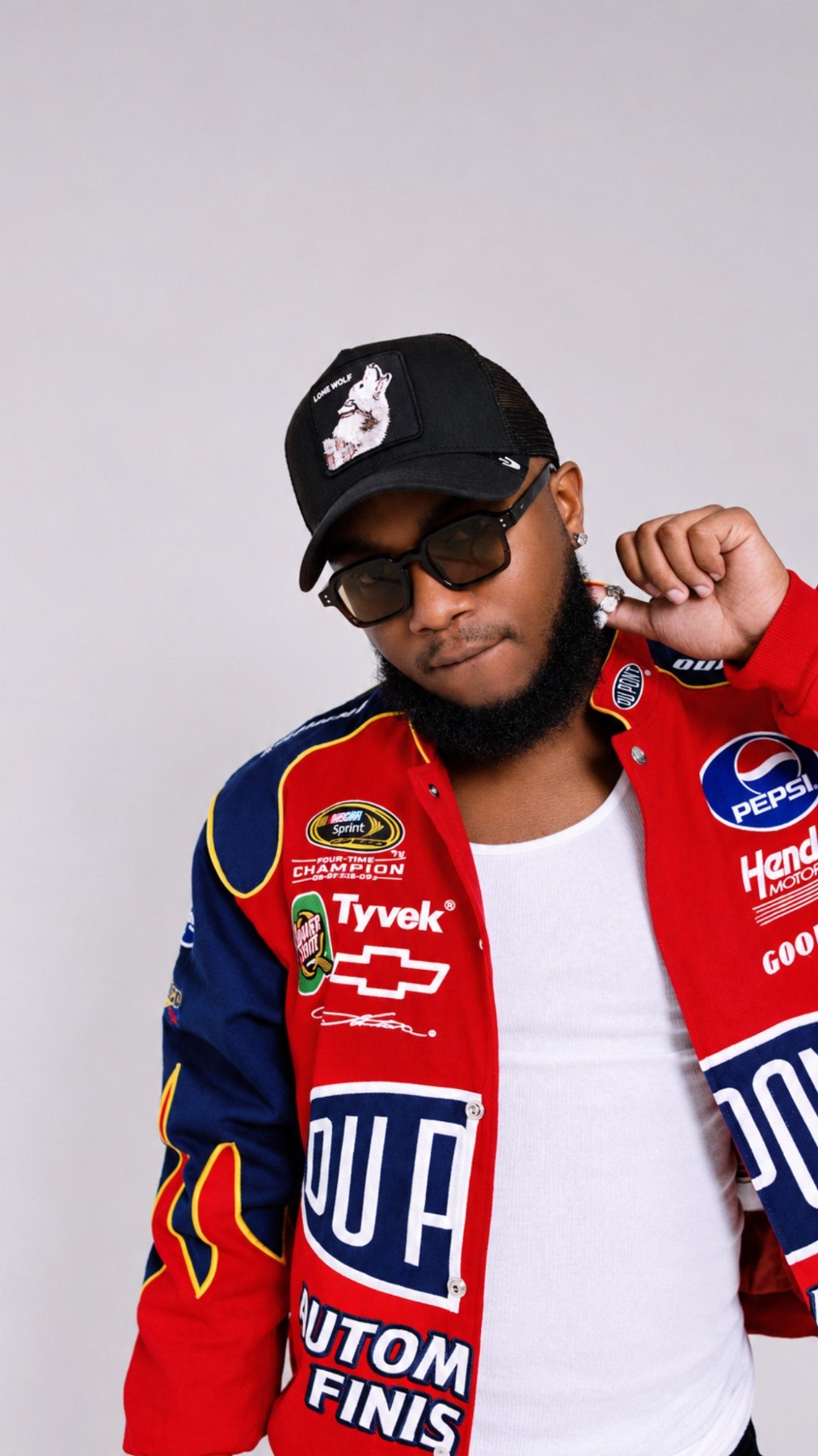 VARCELL in a red racing jacket, black cap and sunglasses
